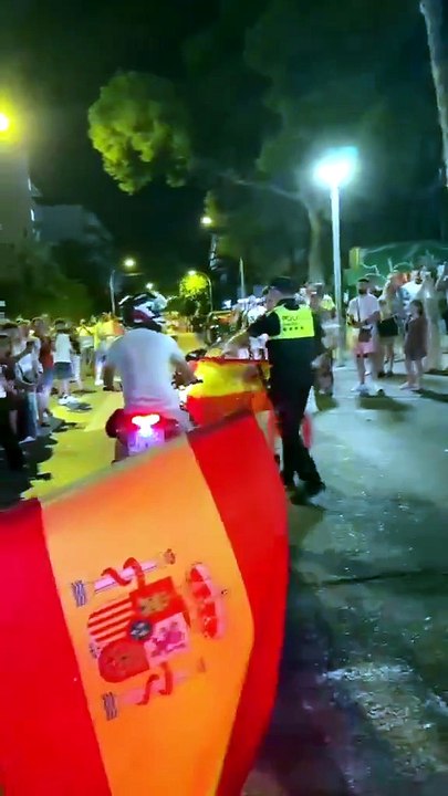 España en una imagen: un policía torea a una moto con la bandera en plena celebración