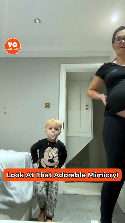 Young Boy Playfully Imitates Pregnant Mother at Home