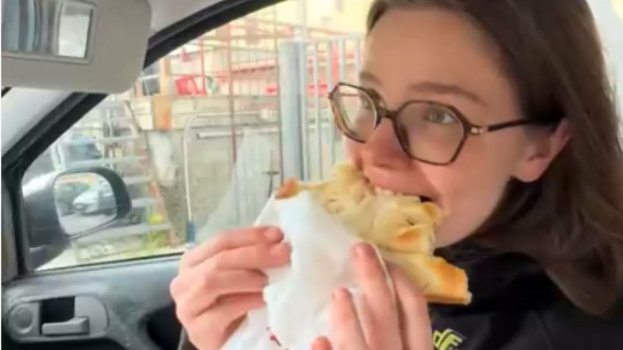 Dog Leans Forward And Takes A Bite Of A Girl’s Food In The Car