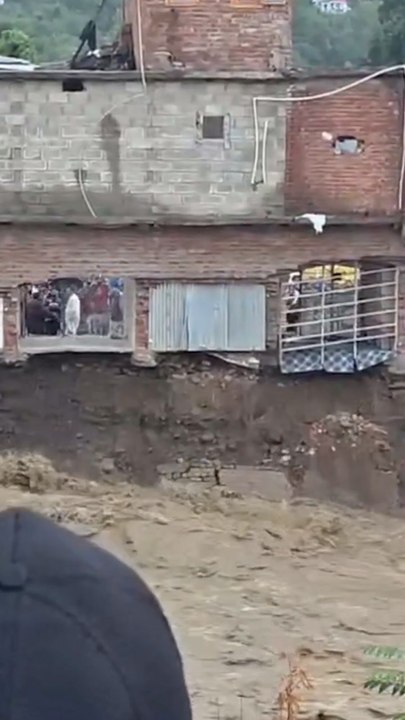 Moment buildings crash into river during India floods