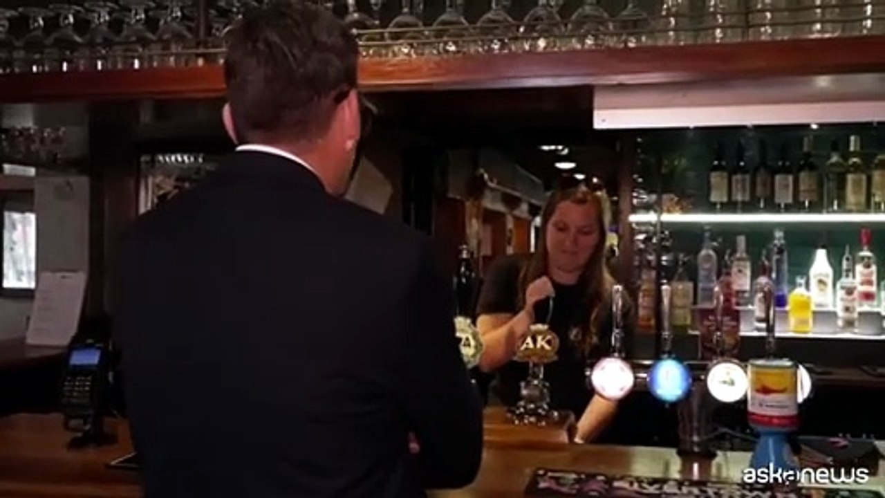 Andy Burnham festeggia il taglio delle tasse al pub con birra in mano