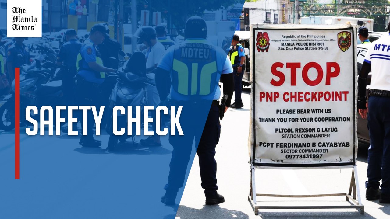 Police examine motorists' documents in Manila checkpoint