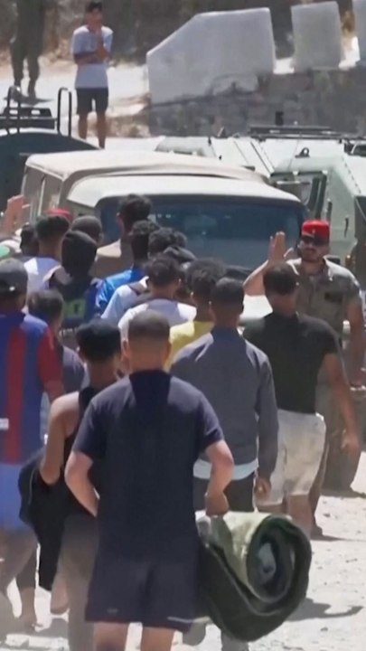 Desperate migrants pack water distribution point