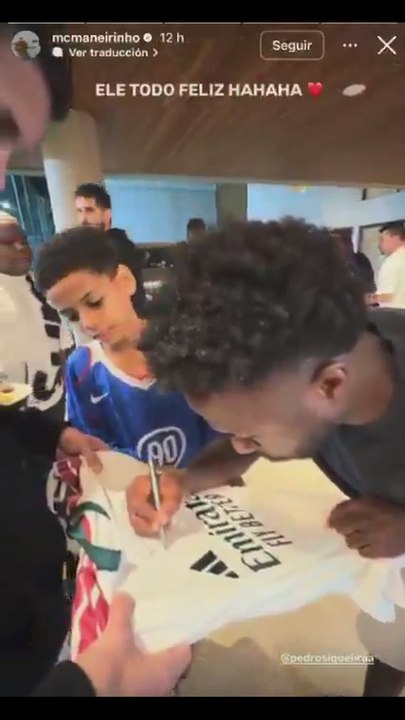 Vinicius firmando una de las nuevas camisetas del Real Madrid