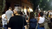 È la seconda sera dalla scomparsa,  e continuano a cantare: un gruppo di gente davanti via Paolo Fabbri civico 43