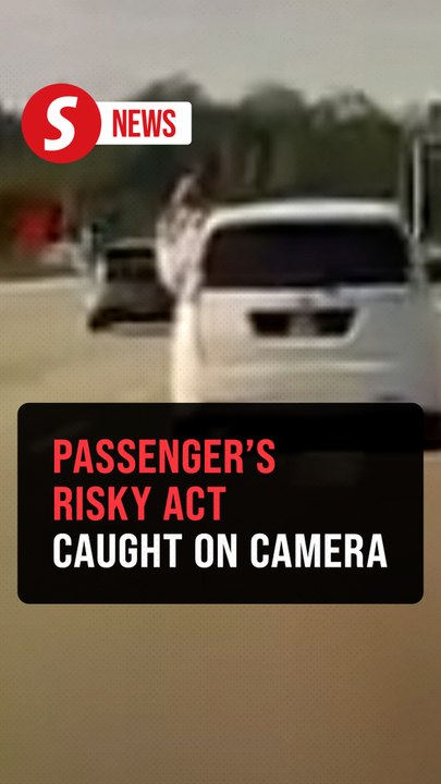Passenger hangs out of a moving car's window on a Kajang highway