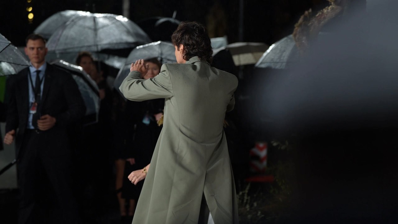 Jacob Elordi sheilds Margot Robbie from the rain