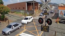 Camera registro carro sendo arrastado por trem no cruzamento
