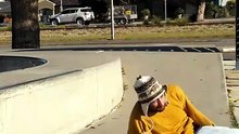 Skateboarder does kickflip from ledge at skatepark and lands on his ankle