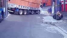 Caminhão quase tomba carregado de tijolo descendo uma rua num bairro