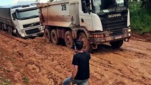 Caminhão basculante teve dificuldade de tira uma carreta numa estrada de muito barro