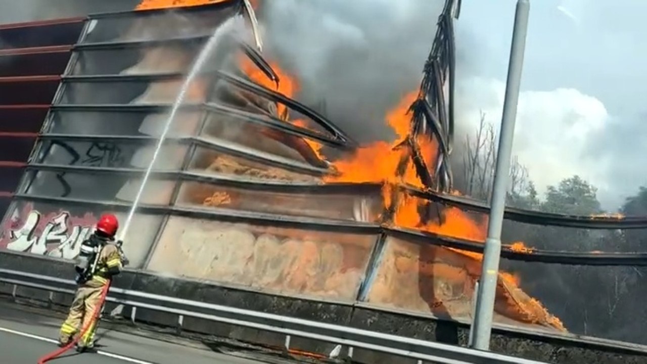 Smoke Rises Along A Highway In Amsterdam As Cars Roll Past