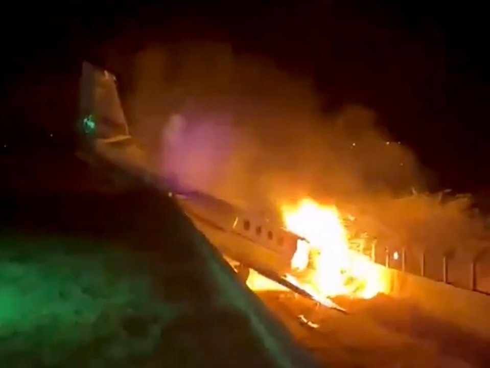 Flugzeug schießt über landebahn hinaus und brennt ab