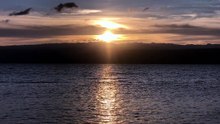 The sun sets behind the mountain.