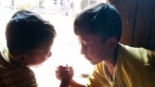 V Little kids are arm wrestling