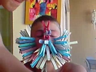 romain avec 80 épingle a linge sur son visage