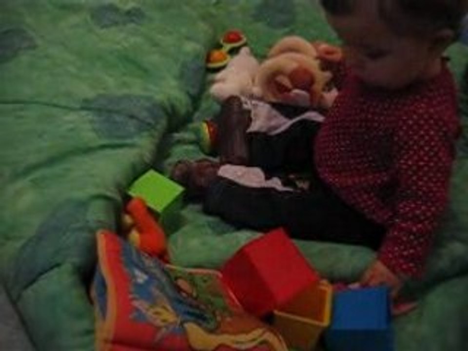 chloé joue par terre sur la couverture