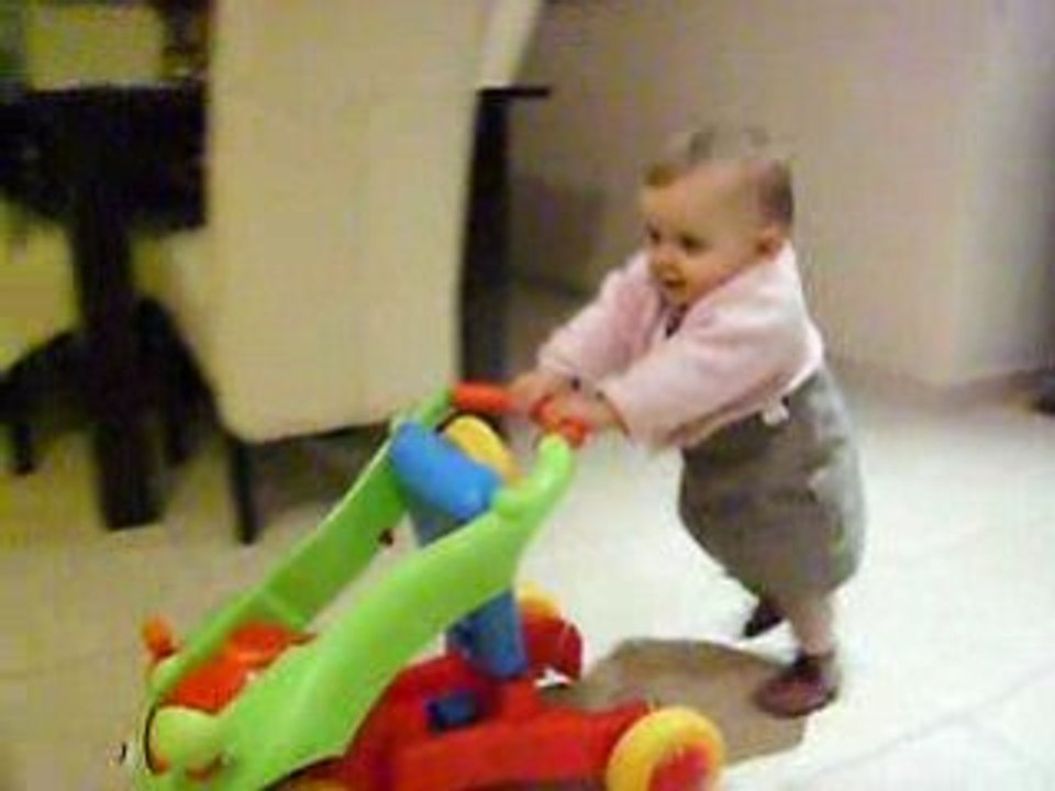 Capucine marche aidée de son pousseur