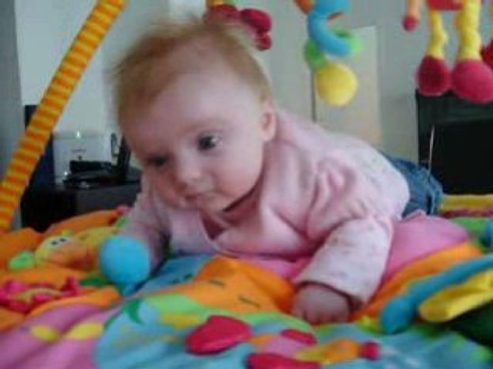 Manon sur son tapis d'éveil sur le ventre