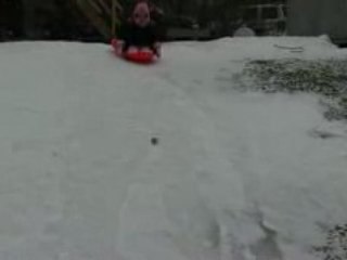 Cassidy sleds down the hill and crashes into Dad