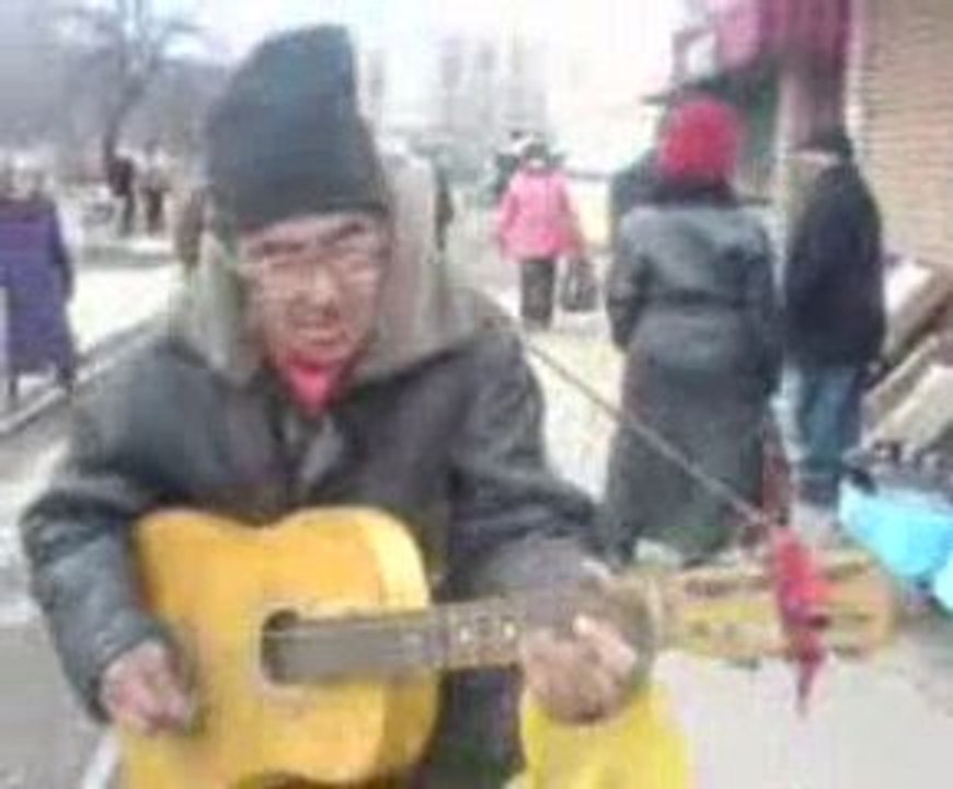 Le sans domicile fixe joue sur la guitare