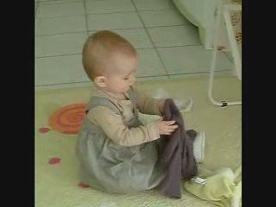 Petite Louise essaie d'enfiler son gilet